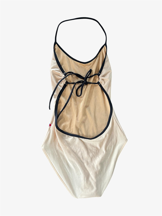 Beige leotard with black trim on a white background