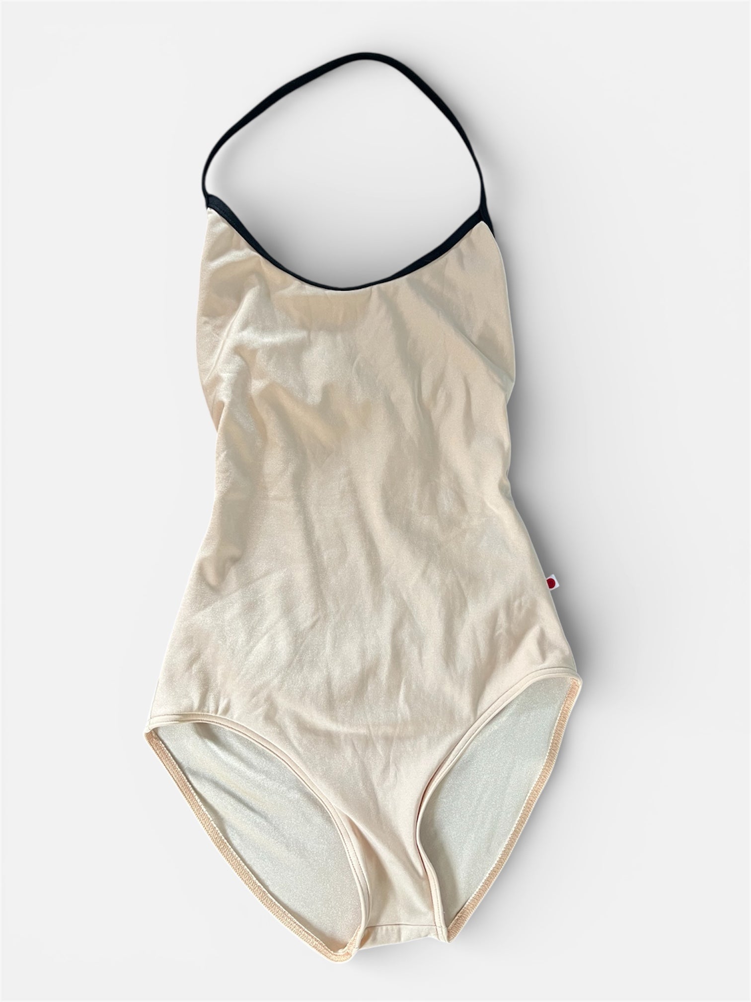Beige leotard with black trim on a white background